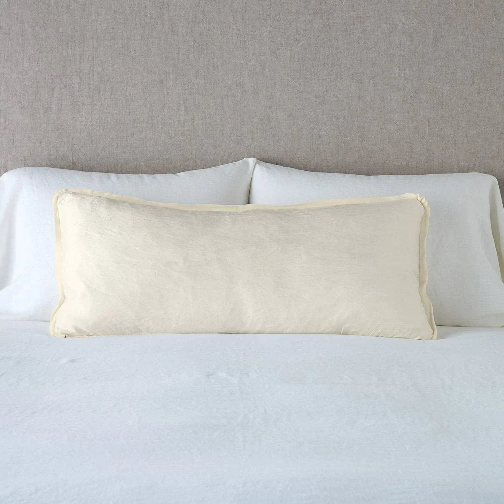 Parchment: 16x36 charmeuse pllow wth silk velvet trim against white sleeping pillows and sheets — straight on with neutral background.