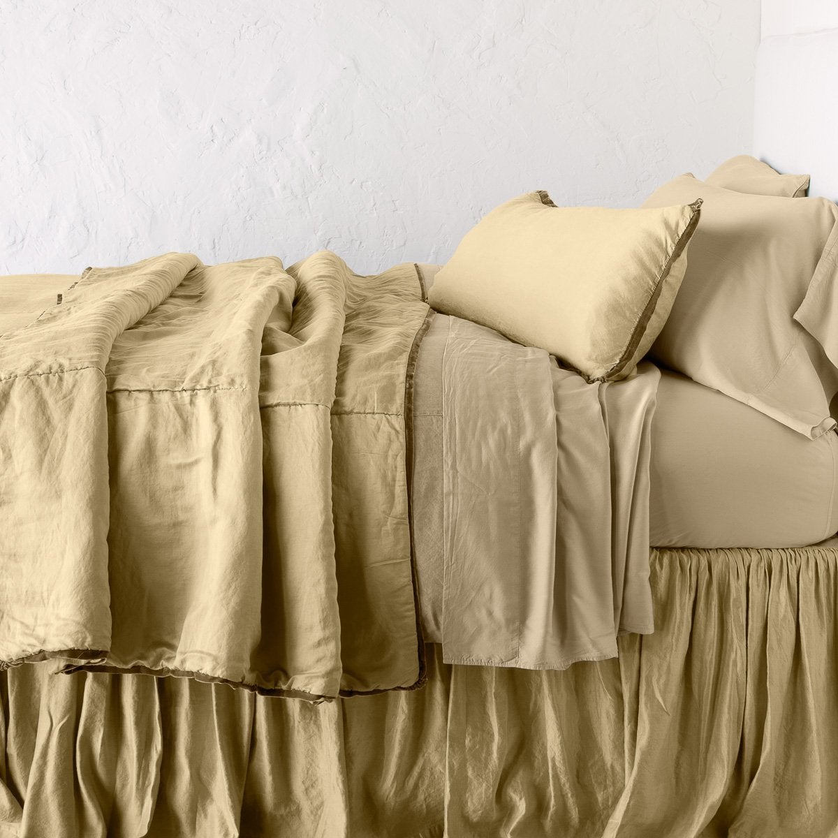 Honeycomb: throw blanket rumpled on a charmeuse monochromatic bed - side view.