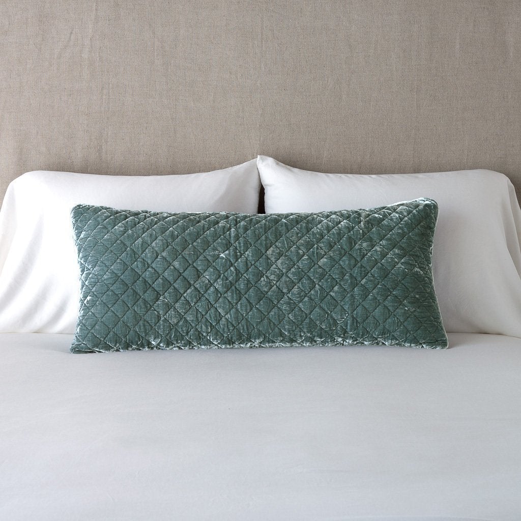 Eucalyptus: 16x36 pillow leaning upright against white sleeping pillows and a neutral headboard.