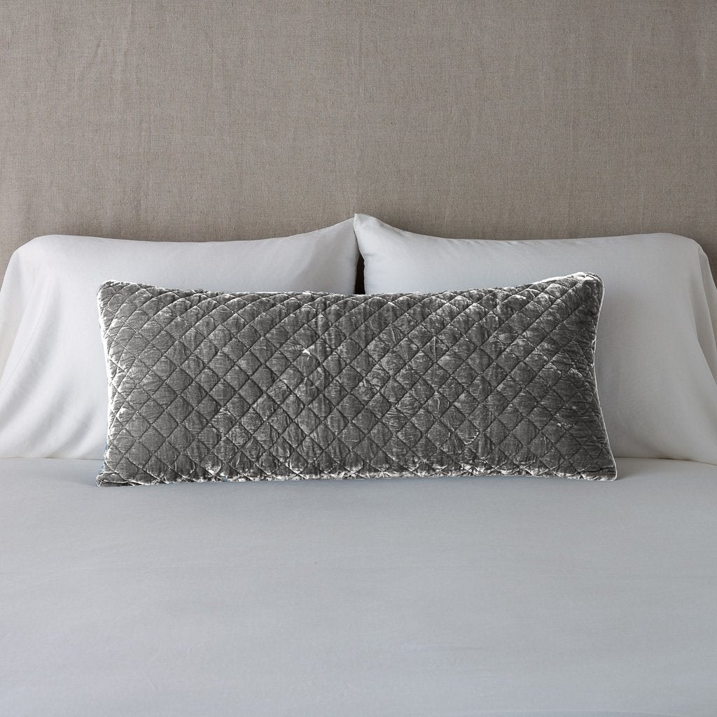 Fog: 16x36 pillow leaning upright against white sleeping pillows and a neutral headboard.