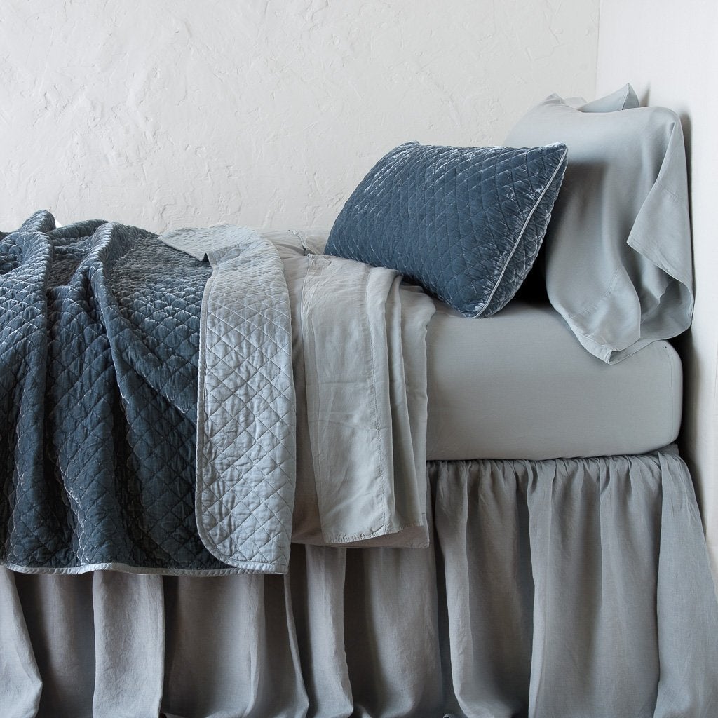 Mineral: 16x36 pillow with rumpled matching coverlet on monochromatic bed - side view.
