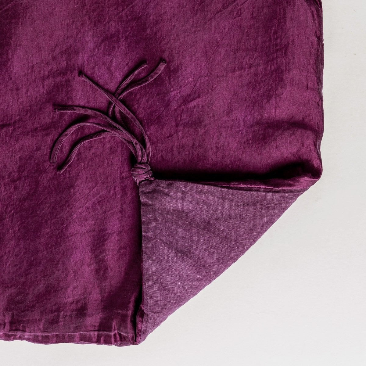 Fig: Close up of blanket, with a corner turned back to showcase the midweight linen back and corner tassel - overhead view.