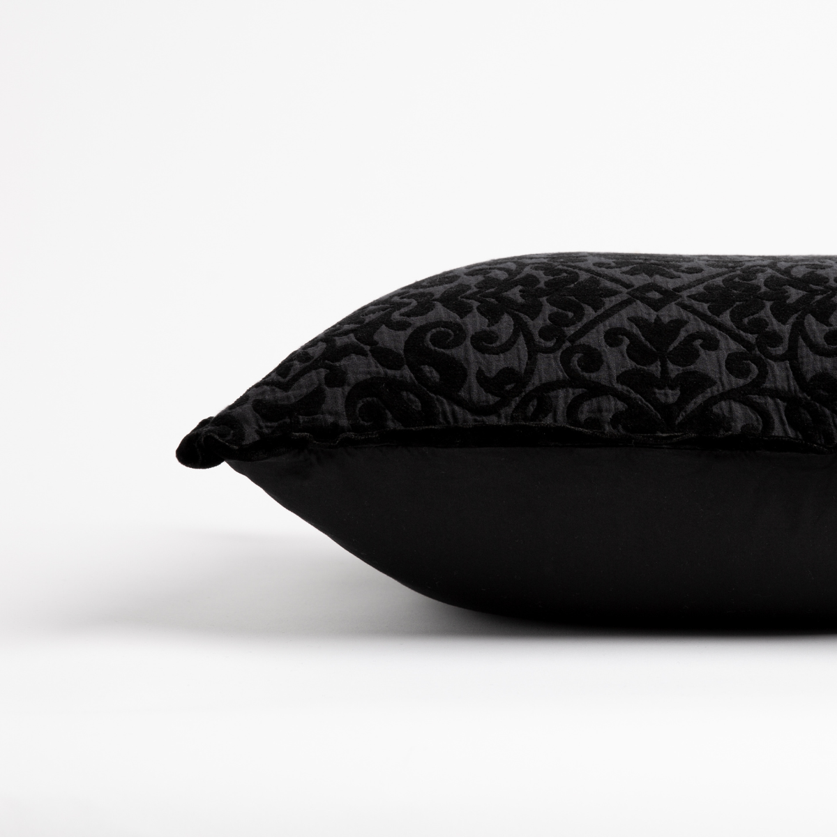 Corvino: side view of 18x18 pillow shows cotton sateen back and silk velvet trim detail β close up against a white background.