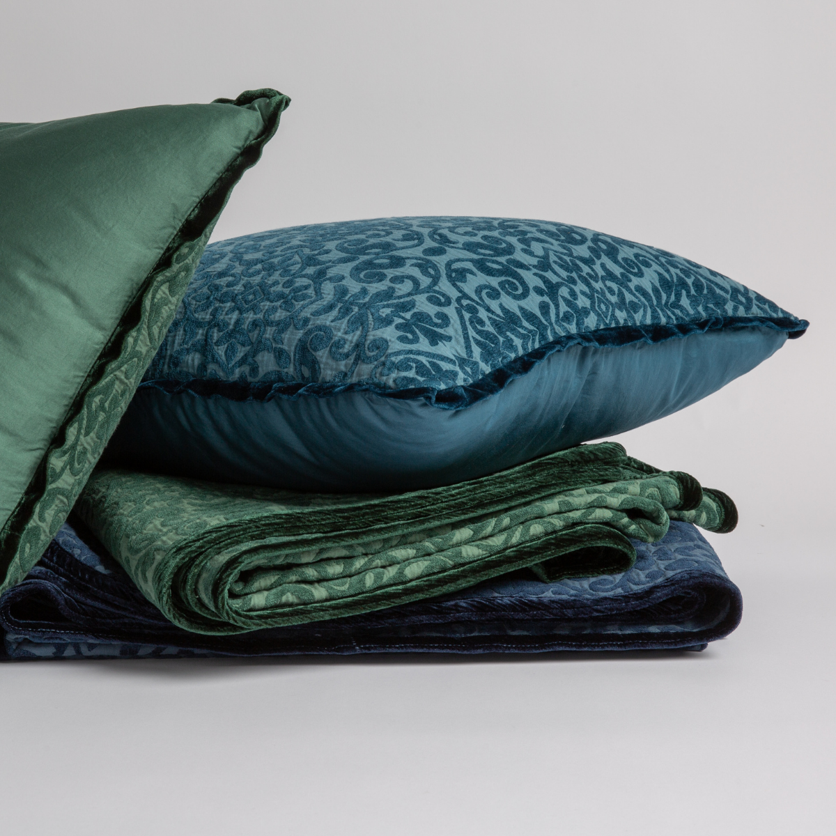 : 18x18 throw pillows and blankets show off the chenile jacquard pattern and silk velvet trim detail — straight on against a white background.