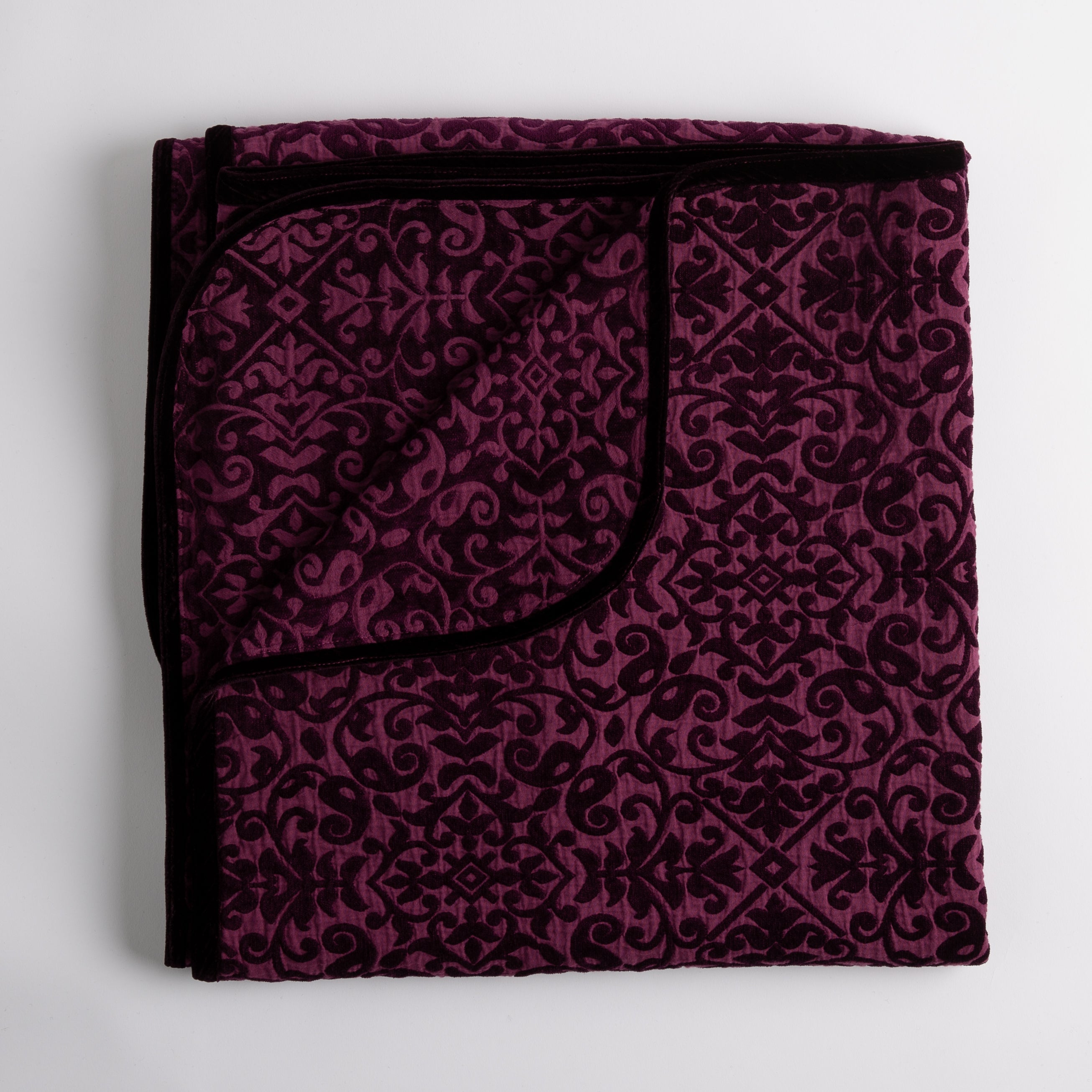 Fig: Folded cotton chenille jacquard blanket with corner folded back — overhead on a plain white background.