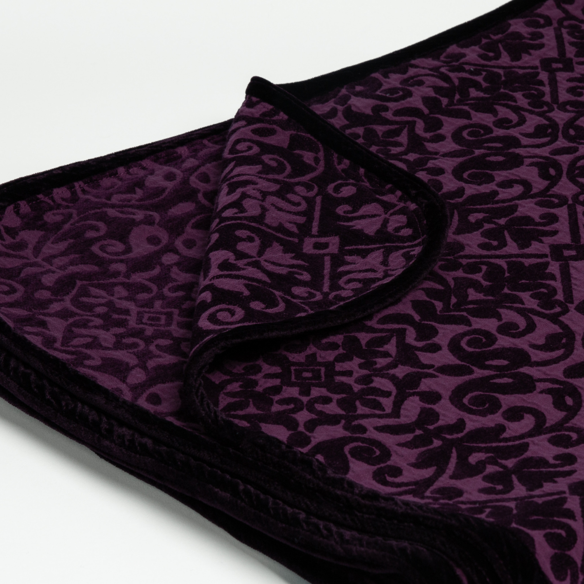Fig: Close up of the blanket folded with a corner pulled back to show the reverse and trim of the blanket.