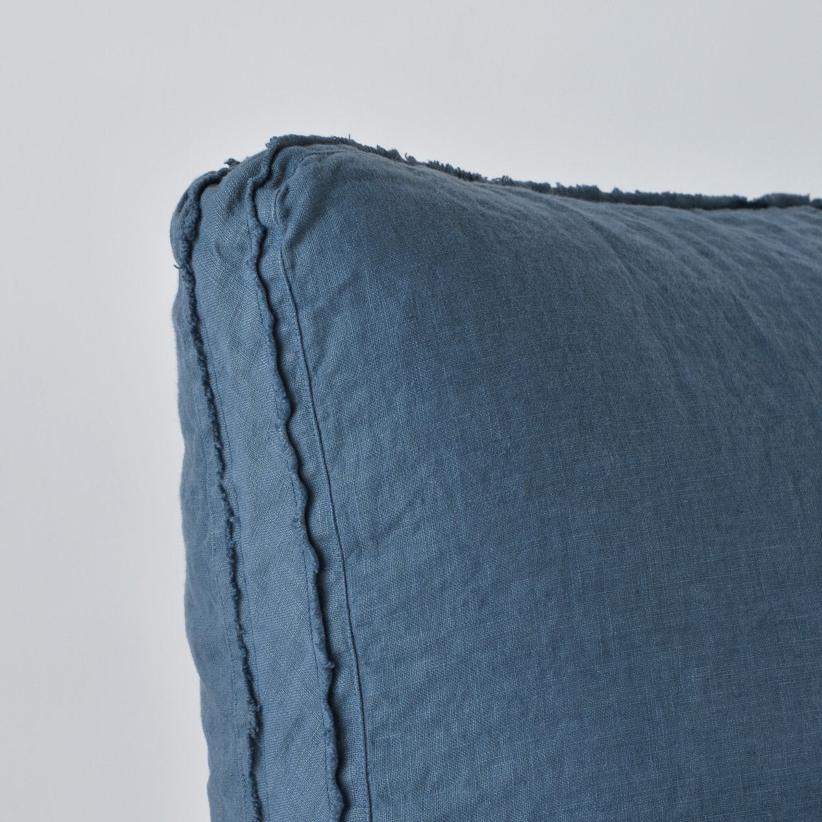 Midnight: Close-up angle of the corner of an Austin sham, highlighting the raw edge trim on either side of the gusset.