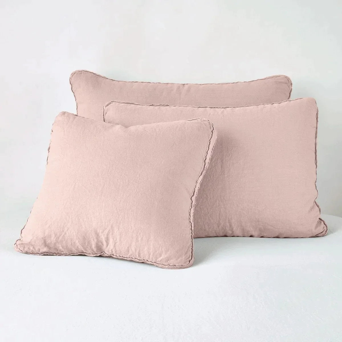 Rouge: Midweight linen shams in rouge colorway shown leaning upright on white background.