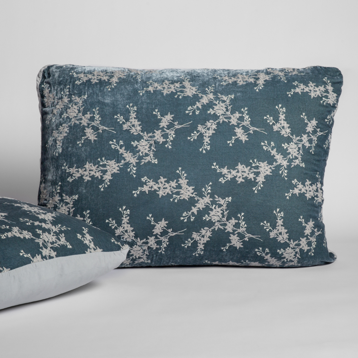 Mineral: A pair of shams shown against a white background with one sham upright and the other on its side to show the tencel back and embroidered silk velvet face. 
