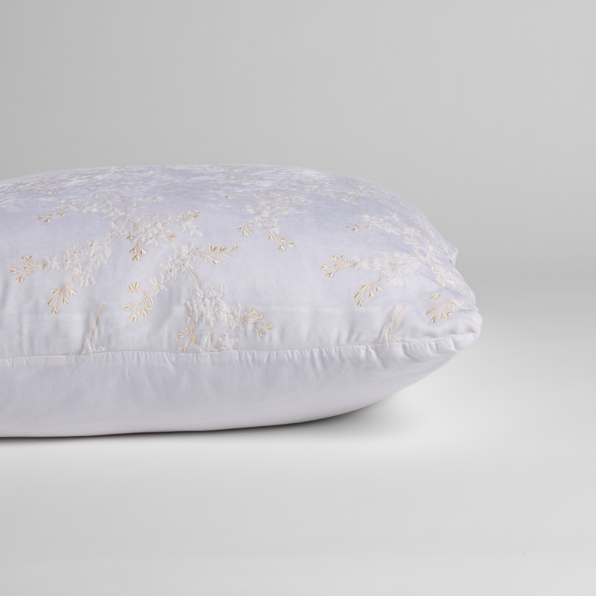 White:  A close-up of the sham shown on its side to display the embroidered silk velvet face and tencel back — shown against a white background. 