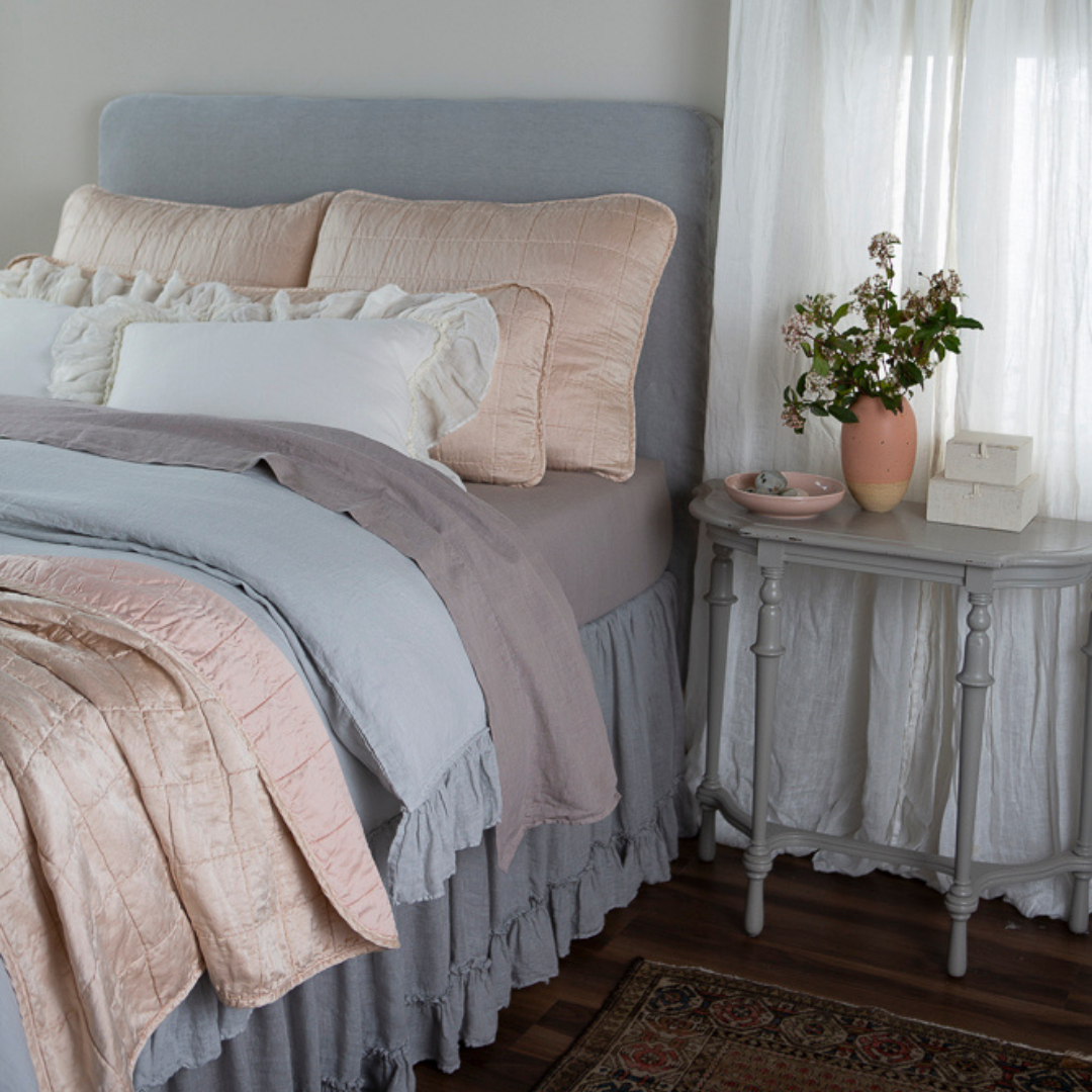 : a bed dressed in linen with Sel shams, 18x54 inch throw pillow and throw blanket in pearl. 