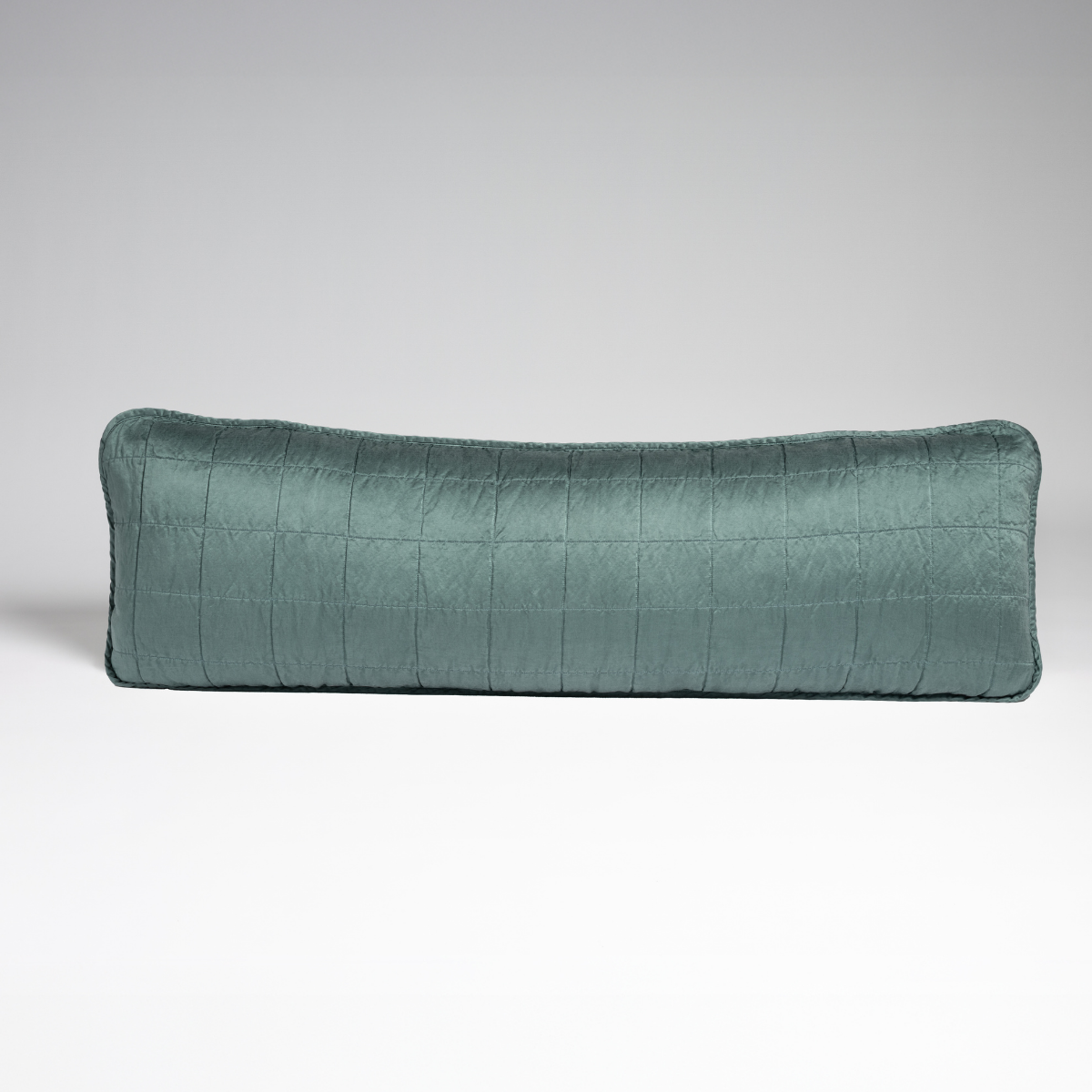 Cenote: A straight-on shot of a square-quilted body pillow in cenote, a vibrant ocean-inspired blue-green, against a white background. 