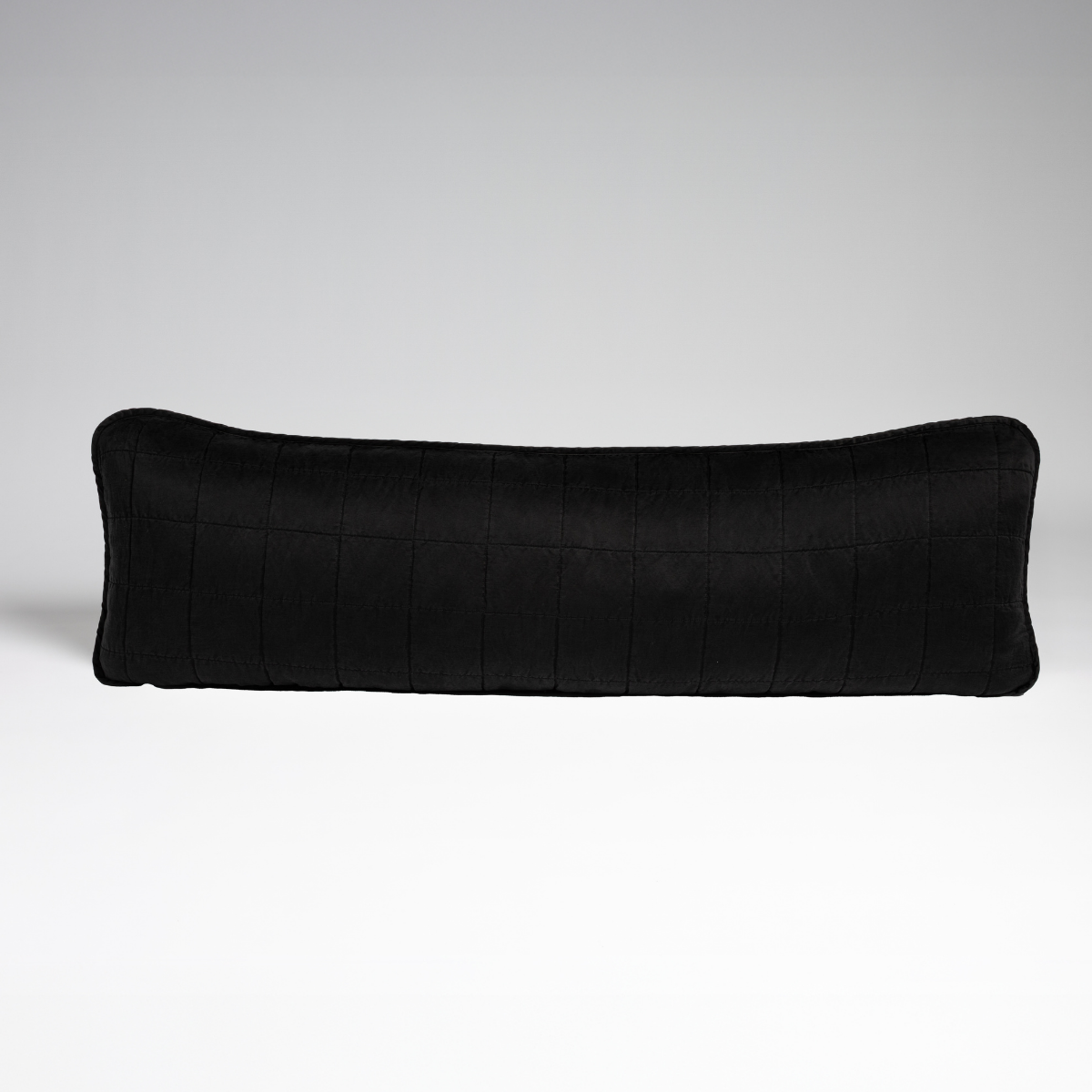 Corvino: A straight-on shot of a square-quilted body pillow in corvino, our classic black, against a white background. 