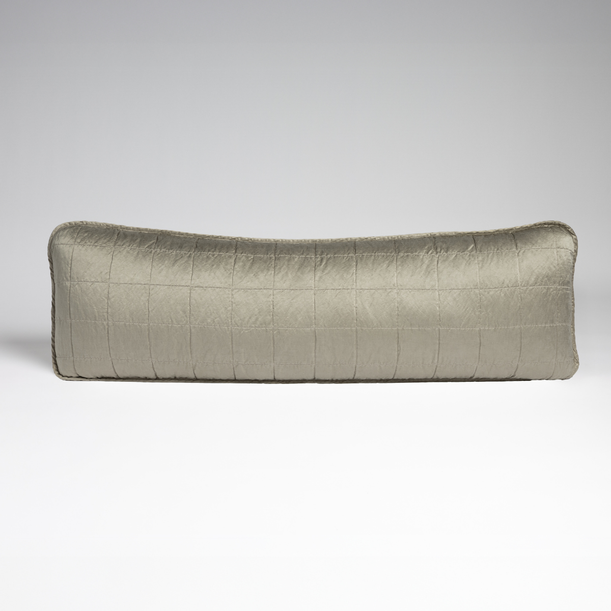 Fog: An overhead shot of a square-quilted rectangle throw pillow in fog, a soft mid-tone grey, against a white background. 