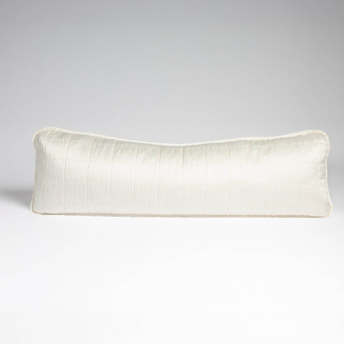 Winter White: A straight-on shot of a square-quilted body pillow in winter white, a softer and warmer tone than our classic white, against a white background. 