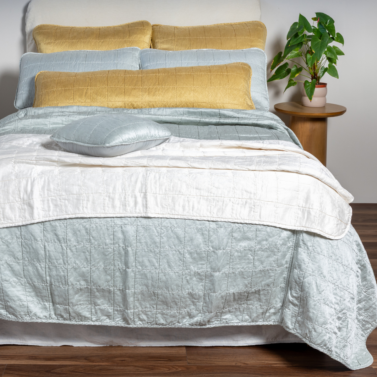 [allvariants]: A straight-on shot of a bed decorated in the new Sel Coverlet, Shams, Blanket, and Throw Pillows in shades of White, Honeycomb, and Cloud. This shot also features a new body-sized throw pillow.