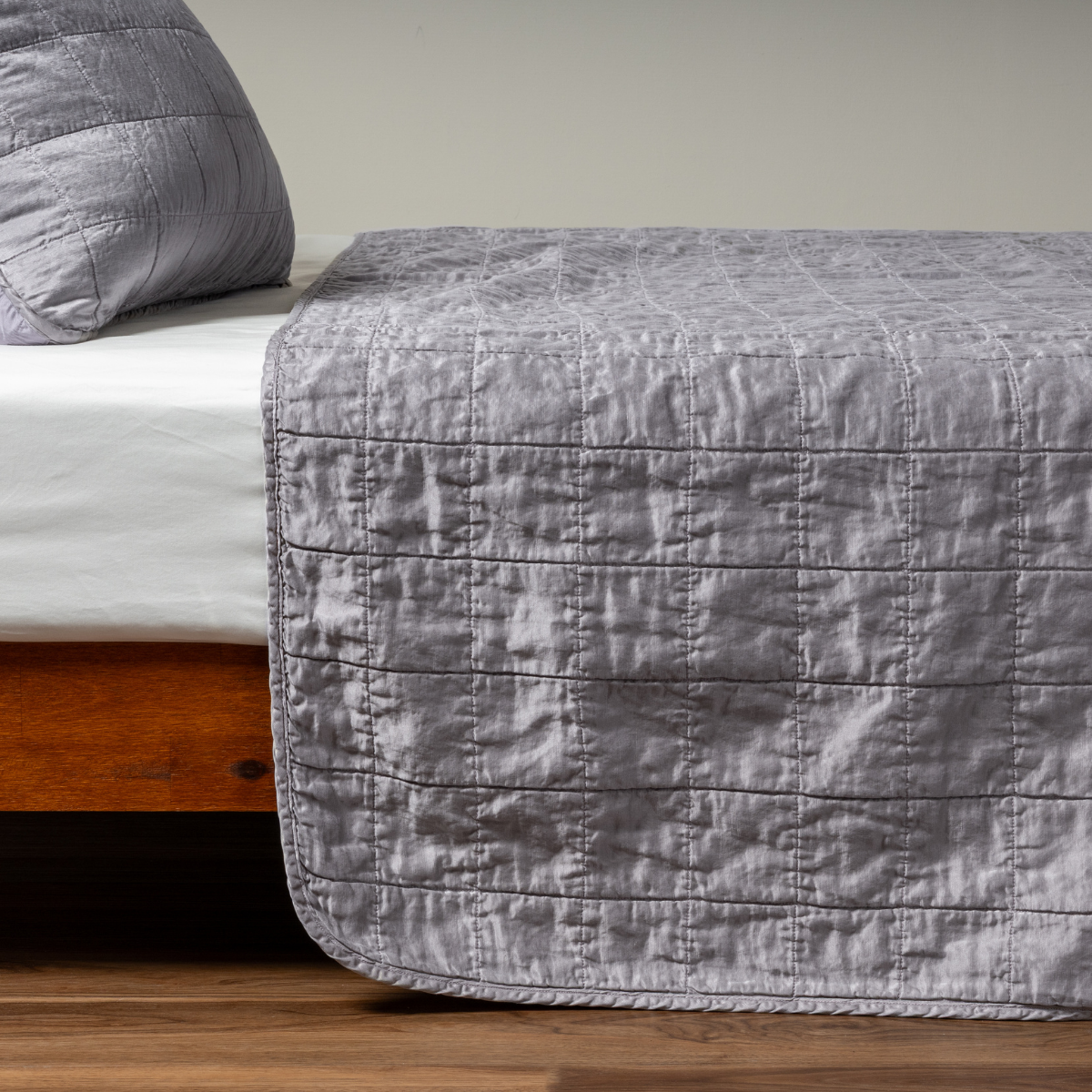 French Lavender: A side shot of a square quilted charmeuse coverlet in french lavender, a neutral violet tone, with its matching sham.  