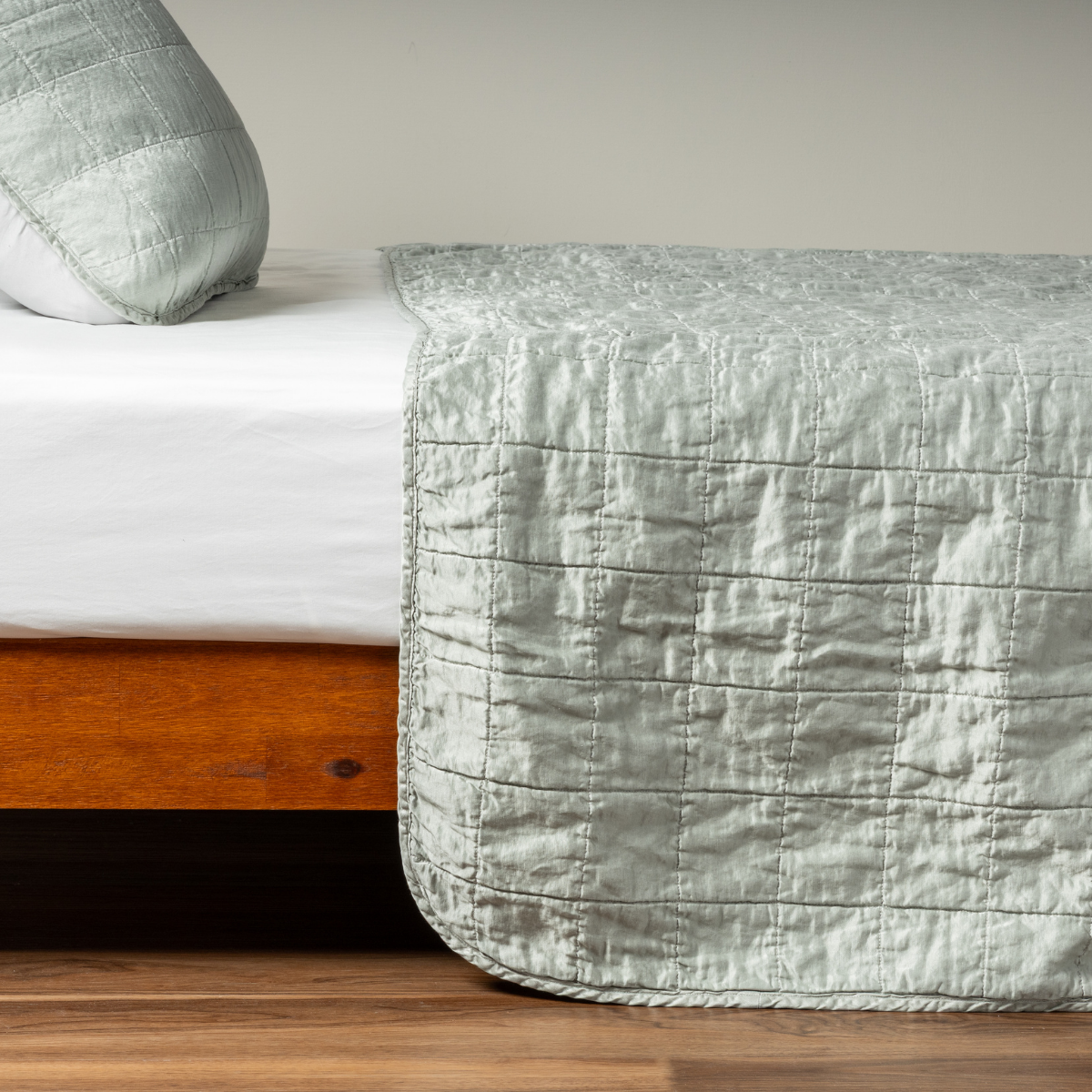 Mineral: A side shot of a square quilted charmeuse coverlet in mineral, a soothing seafoam blue with subtle grey-green undertones, with its matching sham.  