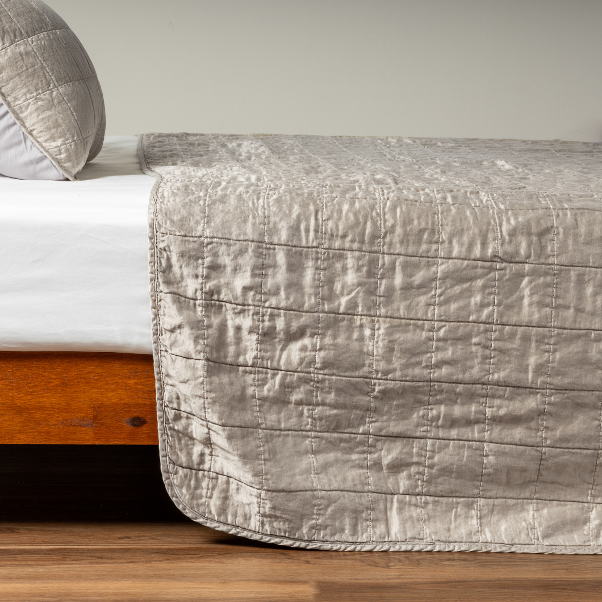 Moonlight: A side shot of a square quilted charmeuse coverlet in moonlight, a saturated, cool, mid-dark grey tone, with its matching sham.  