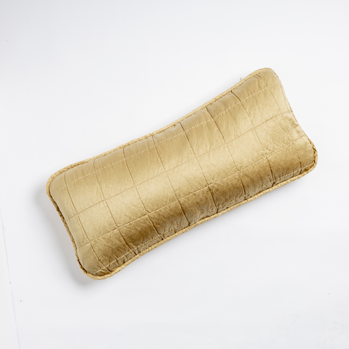 Honeycomb: An overhead shot of a square-quilted rectangle throw pillow in honeycomb, a warm golden tone, against a white background. 