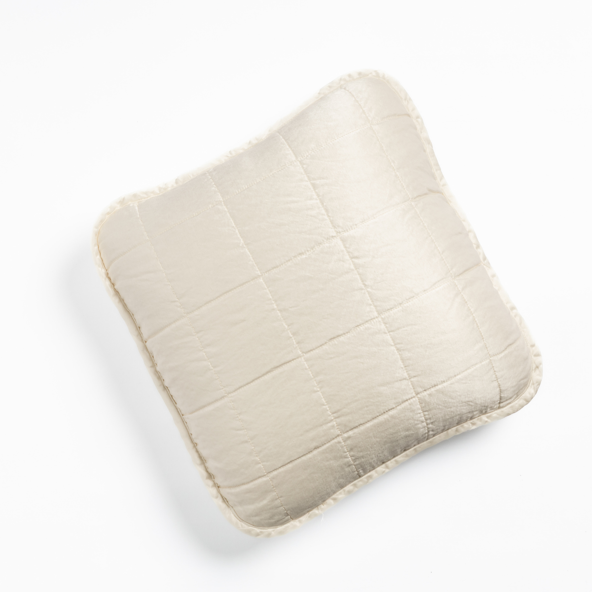 Winter White: An overhead shot of a square-quilted square throw pillow in winter white, a softer and warmer tone than our classic white, against a white background. 