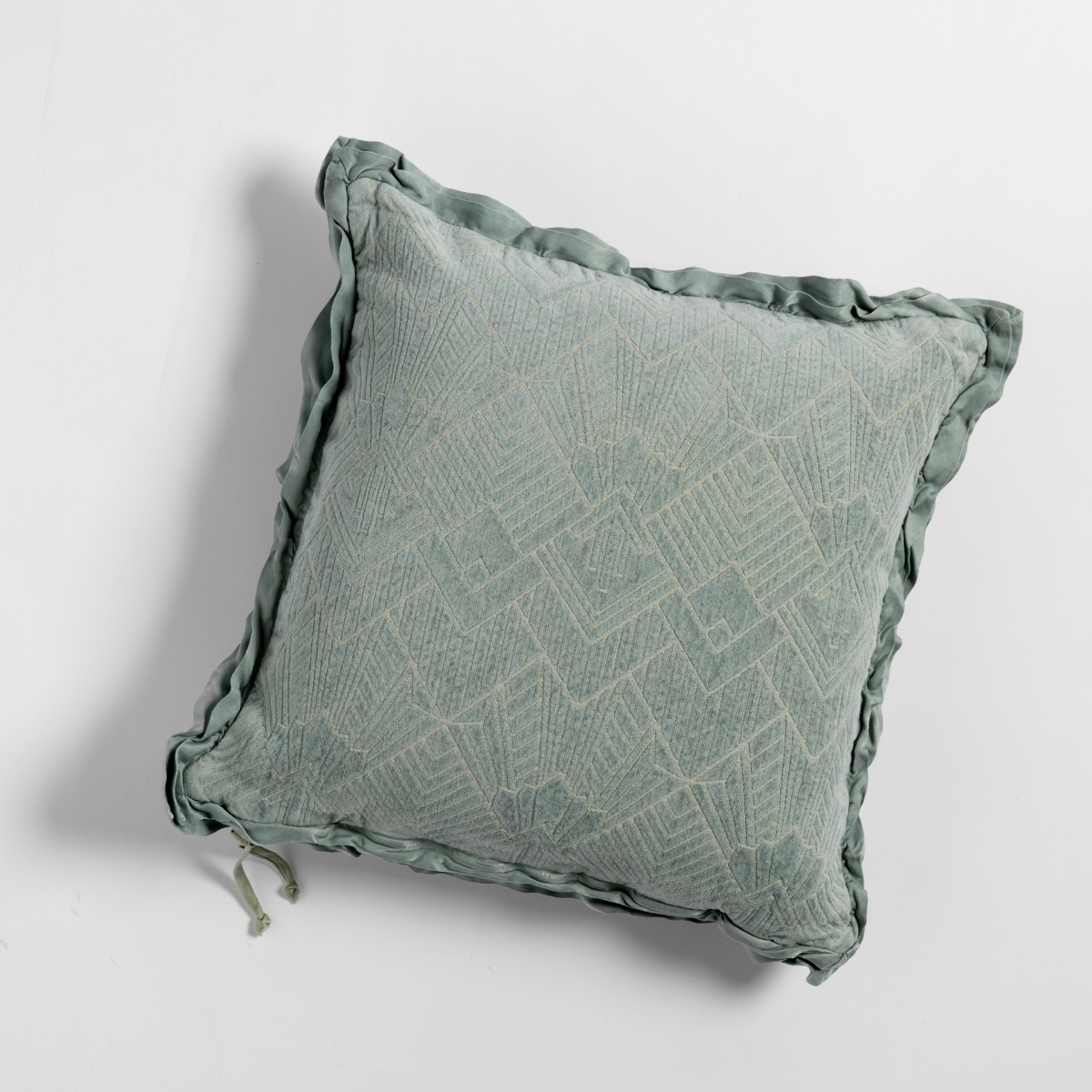 Eucalyptus: The chenille side of a textured throw pillow with contrasting ruffled edges, shot from overhead against a plain background.