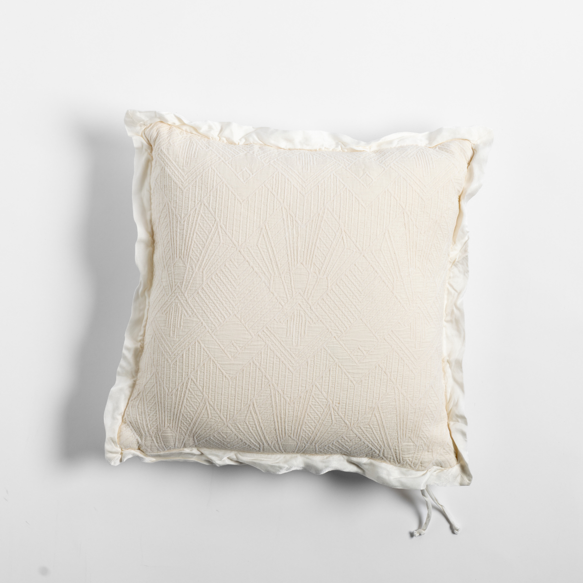 Natural: The cotton jacquard side of a textured throw pillow with contrasting ruffled edges, shot from overhead against a plain background.