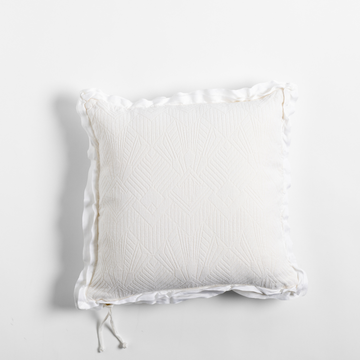Winter White: The chenille side of a textured throw pillow with contrasting ruffled edges, shot from overhead against a plain background.