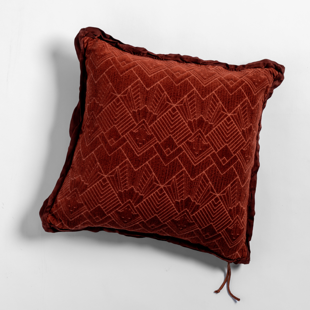 Autumn: The chenille side of a textured throw pillow with contrasting ruffled edges, shot from overhead against a plain background.