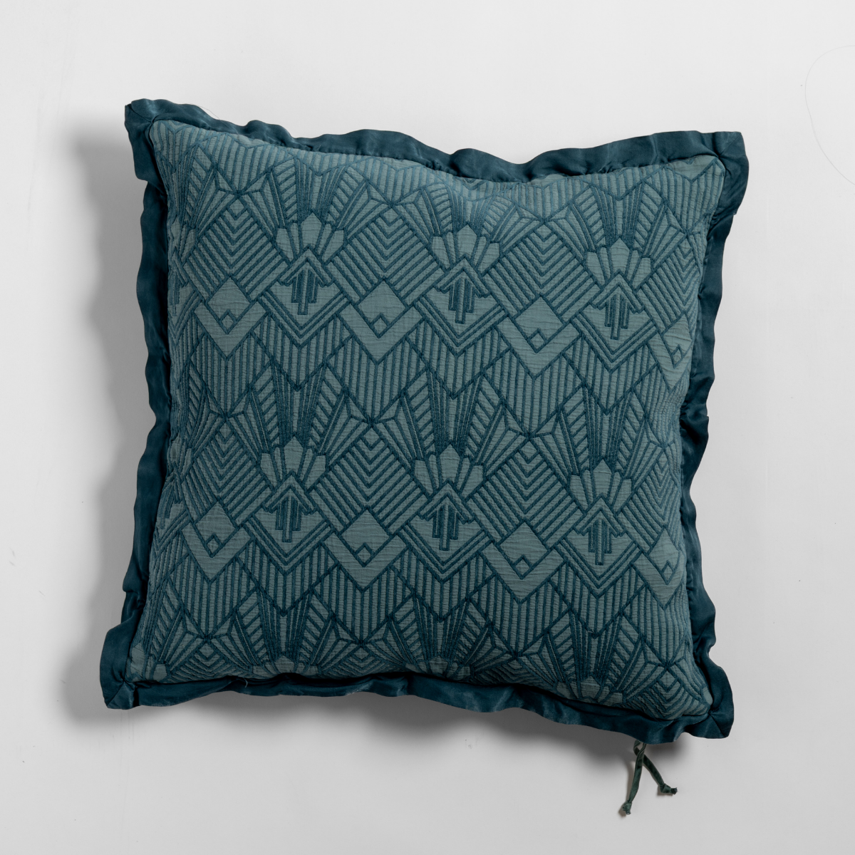 Cenote: The cotton jacquard side of a textured throw pillow with contrasting ruffled edges, shot from overhead against a plain background.