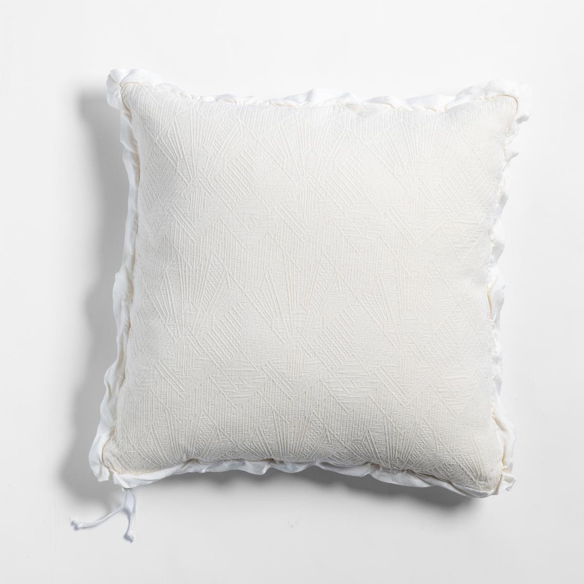 Natural: The cotton jacquard side of a textured throw pillow with contrasting ruffled edges, shot from overhead against a plain background.