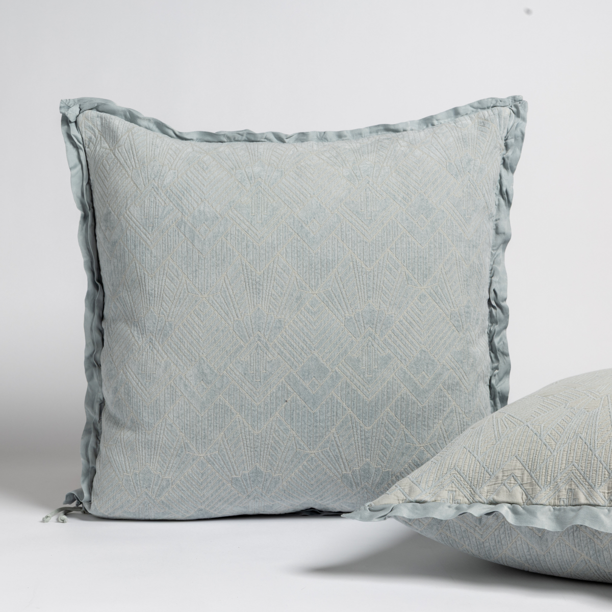 Cloud: Two art deco patterned shams, one upright and one on its side, against a plain background.