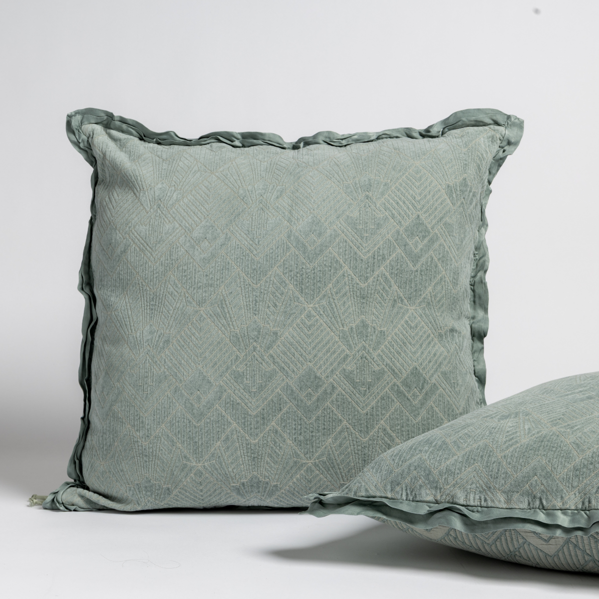 Eucalyptus: Two art deco patterned shams, one upright and one on its side, against a plain background.