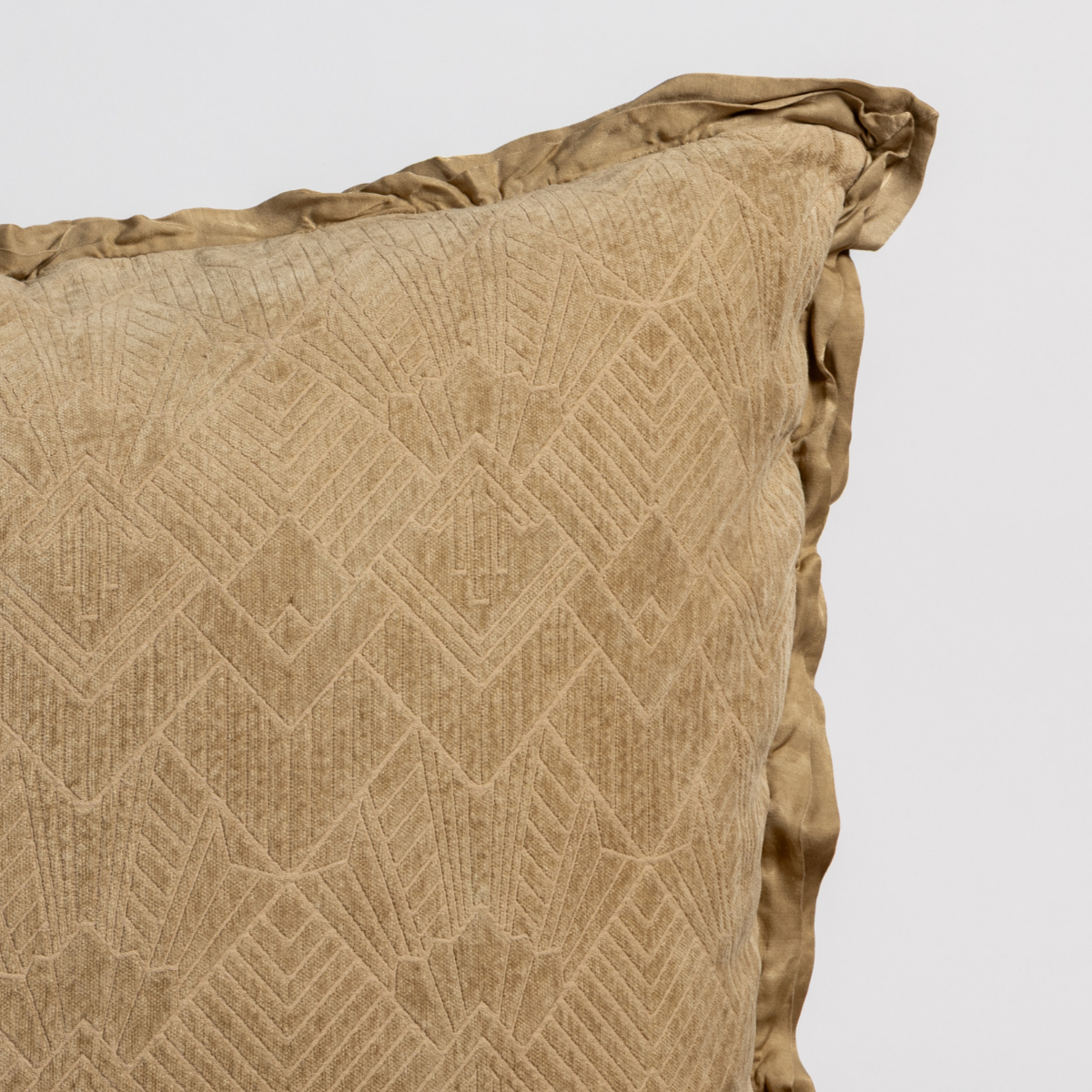 Honeycomb: Close-up of a textured pillow sham corner with a satin ruffle, shot against a plain background.