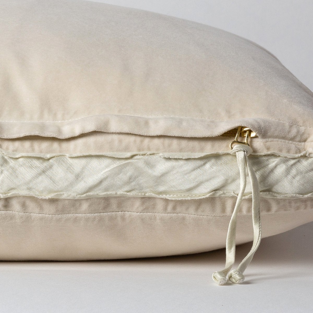 Parchment: Close-up of charmeuse gusset, raw-edge trim, and brass zipper detail  on cotton velvet sham - side view.