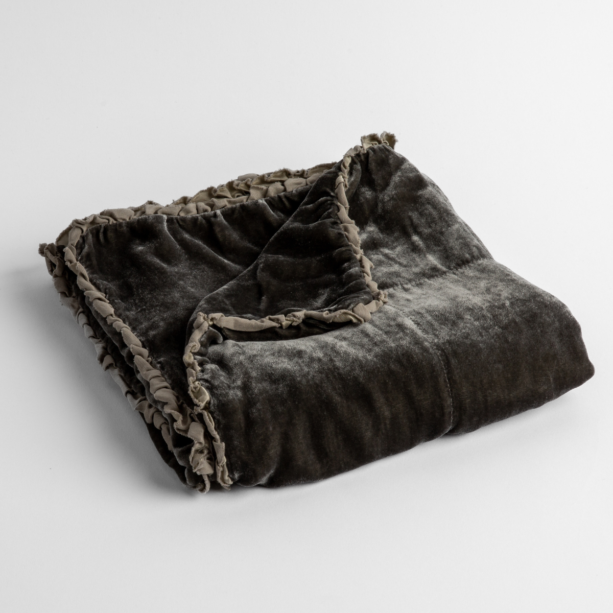 Fog: silk velvet baby blanket with charmeuse trim shown slightly overhead with a corner folded back to show trim detail against a white background. 