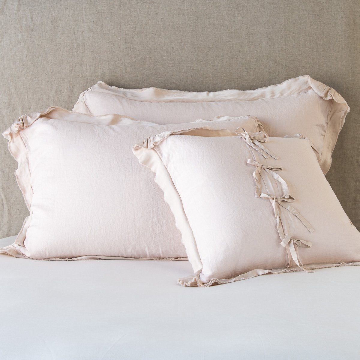 Pearl: satin trimmed linen shams showing the front and back of the sham with tie closures. 