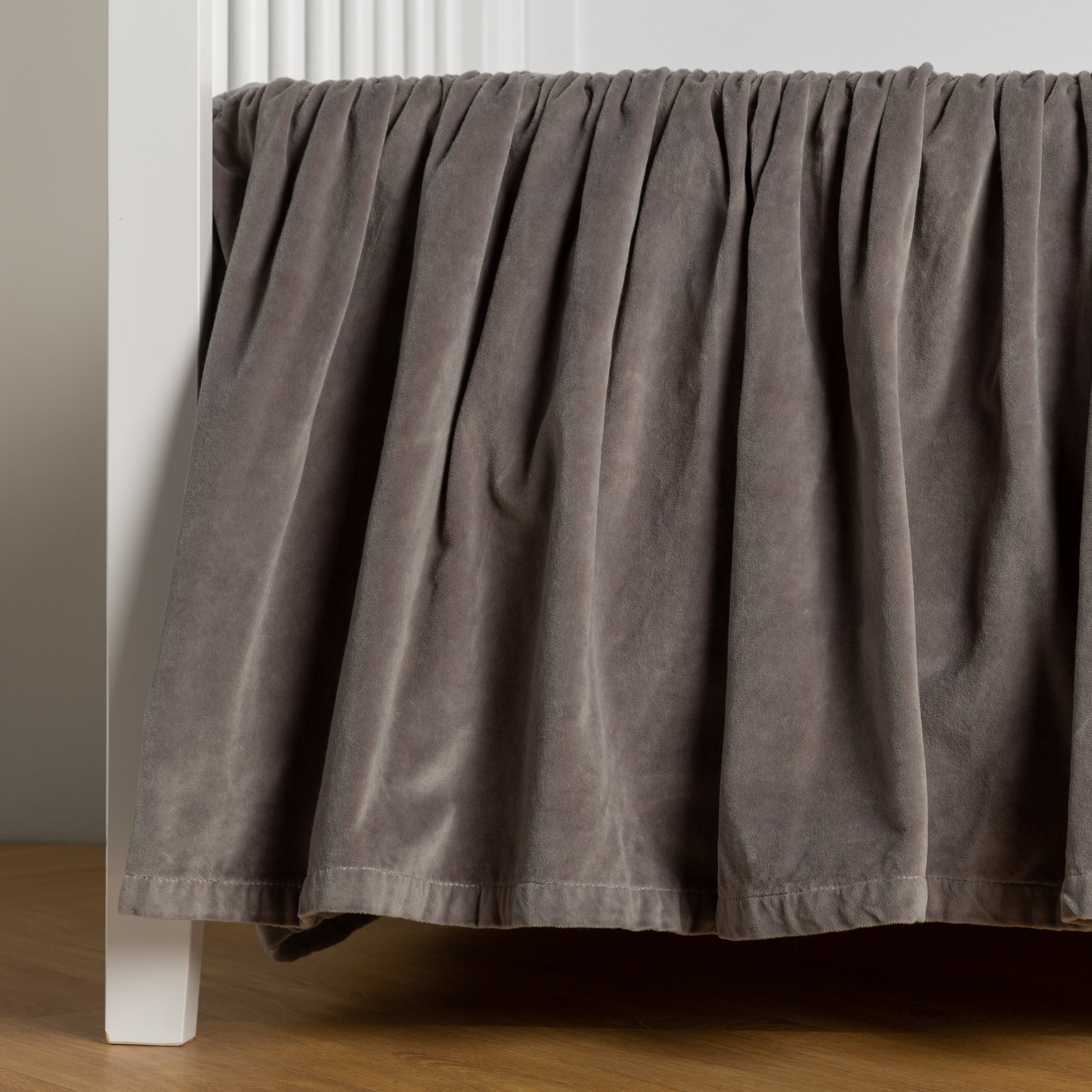 Moonlight:  cotton velvet crib skirt shown on a white crib . 