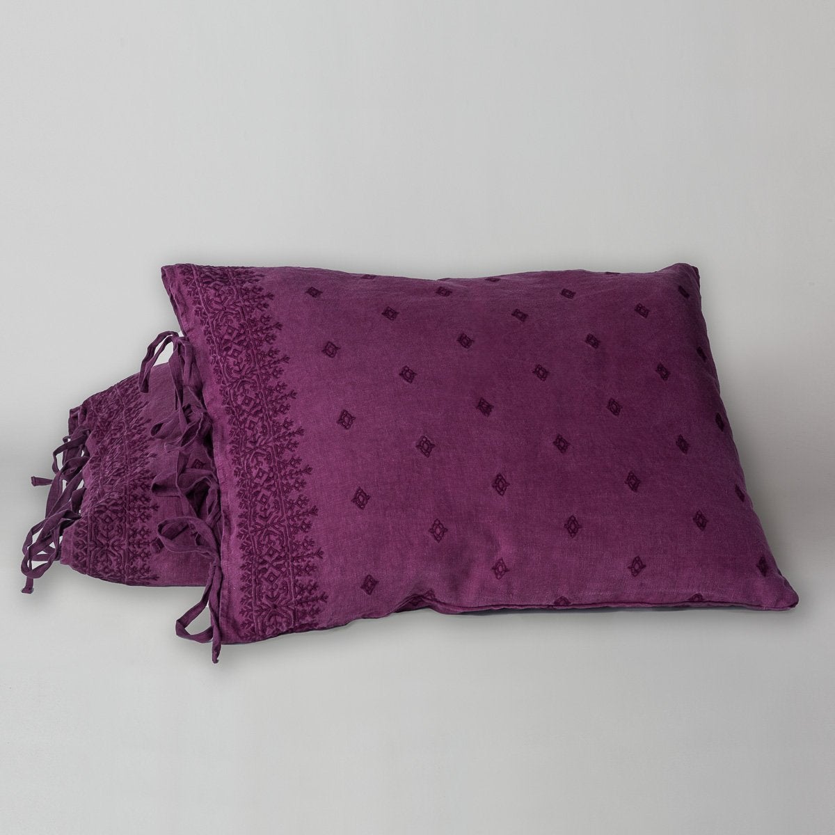 Fig: standard sham leaning against a king sham, on a white background and at a slight angle to showcase the linen side-tie closure.