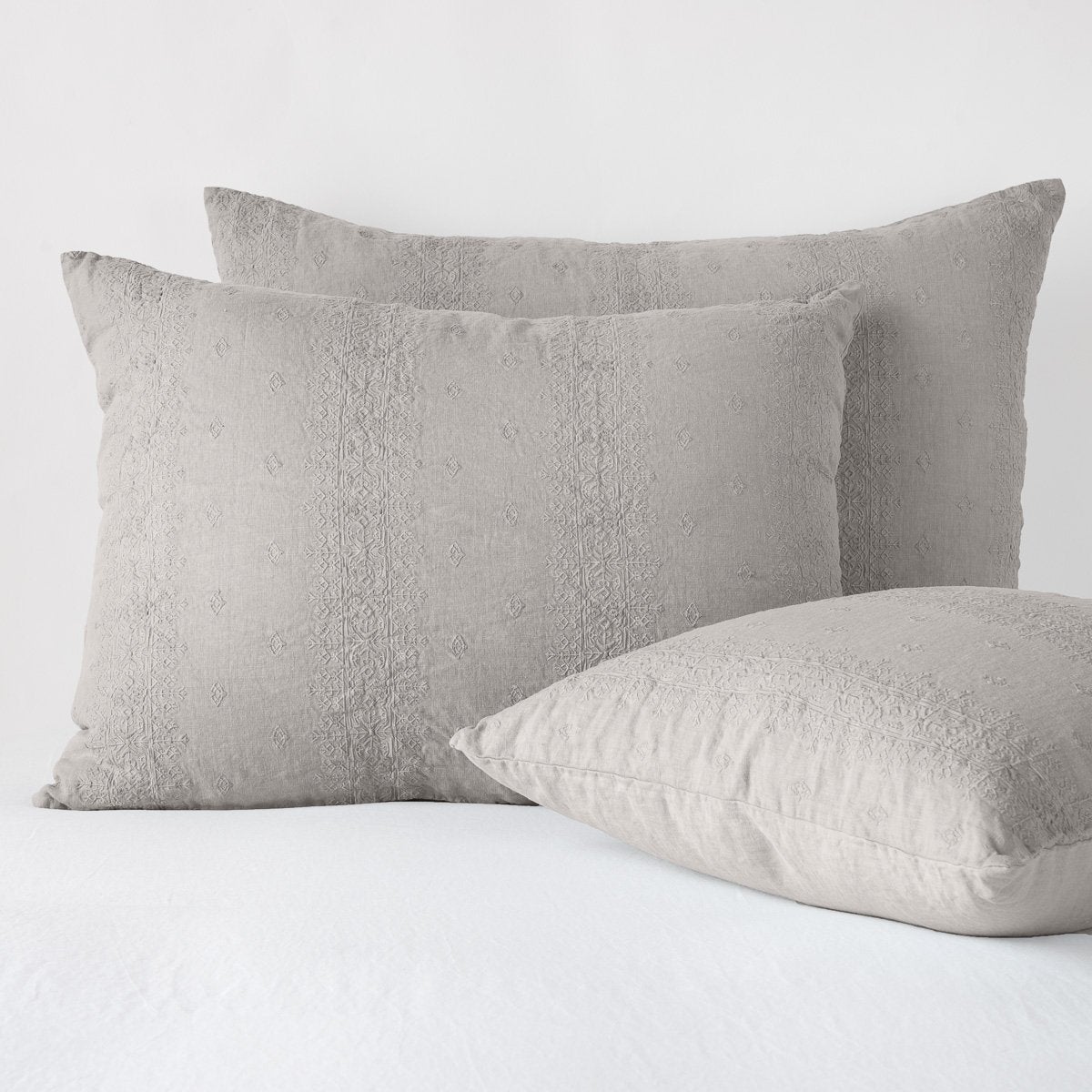 : Ines shams in fog - two leaning upright and one laying flat at an angle, against a white background.