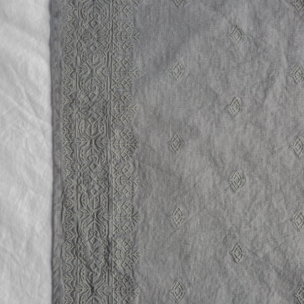 Mineral: A close up of Ines, midweight linen with cotton embroidery, in mineral, a soothing seafoam blue with subtle grey-green undertones. 