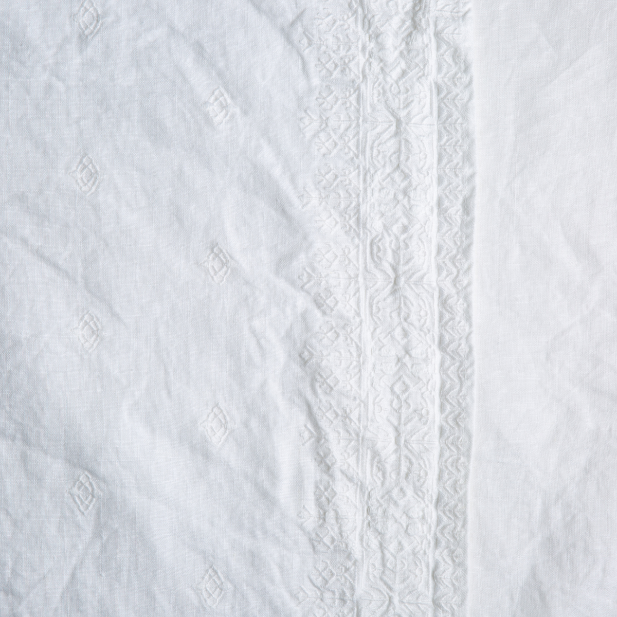 White: A close up of embroidered midweight linen fabric in classic white.