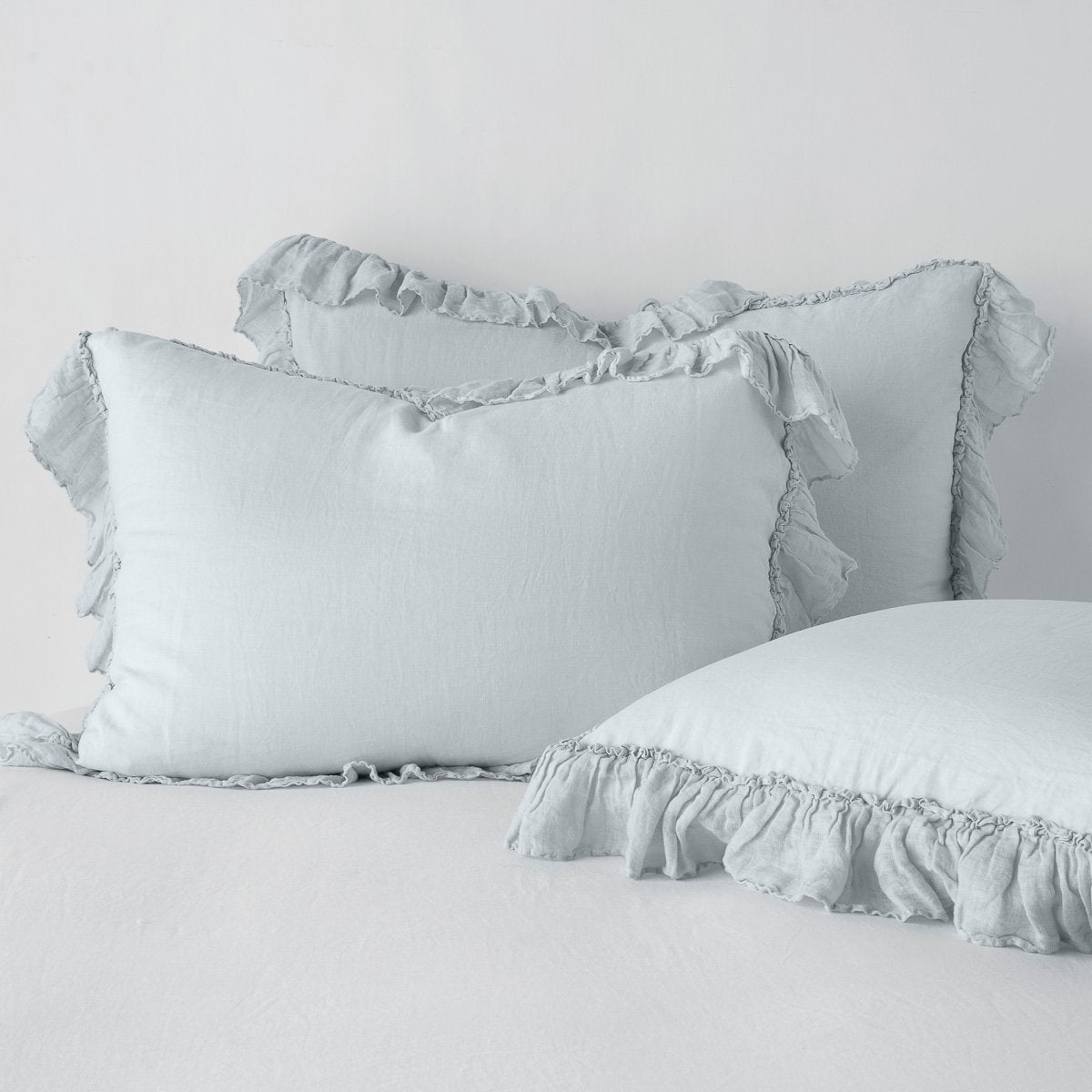 Cloud: two shams leaning upright and one laying flat at an angle in the foreground, against a blank background.