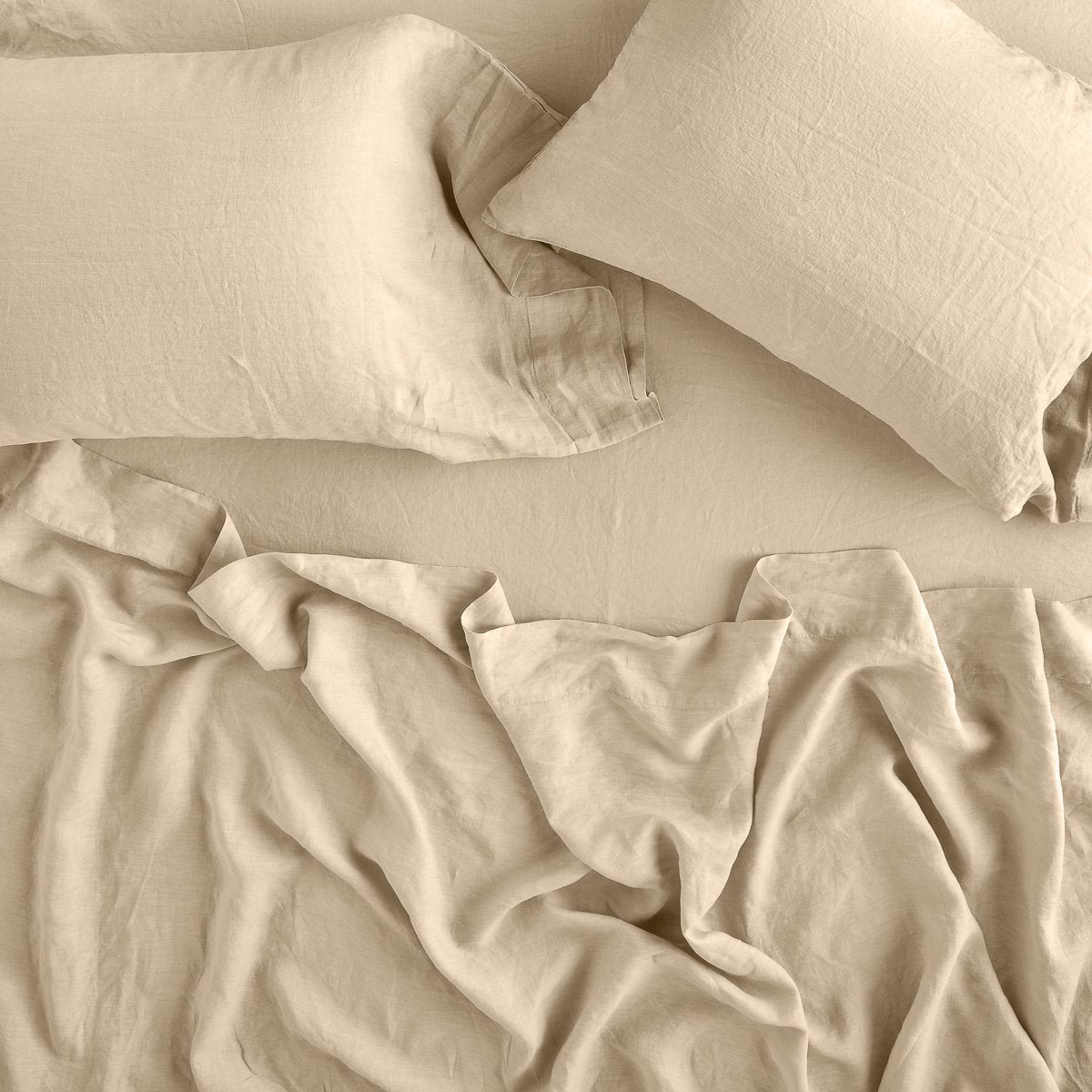 Honeycomb: sleeping pillows laid flat on rumpled matching sheeting - overhead view.