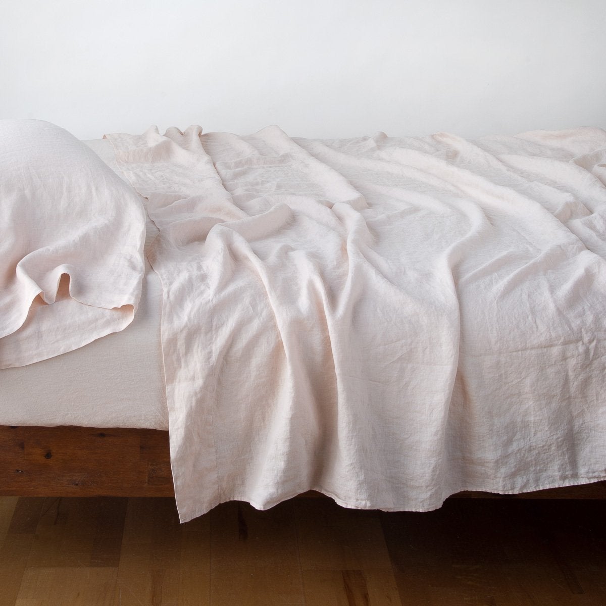 Pearl: sleeping pillow with matching rumpled sheeting - side view.