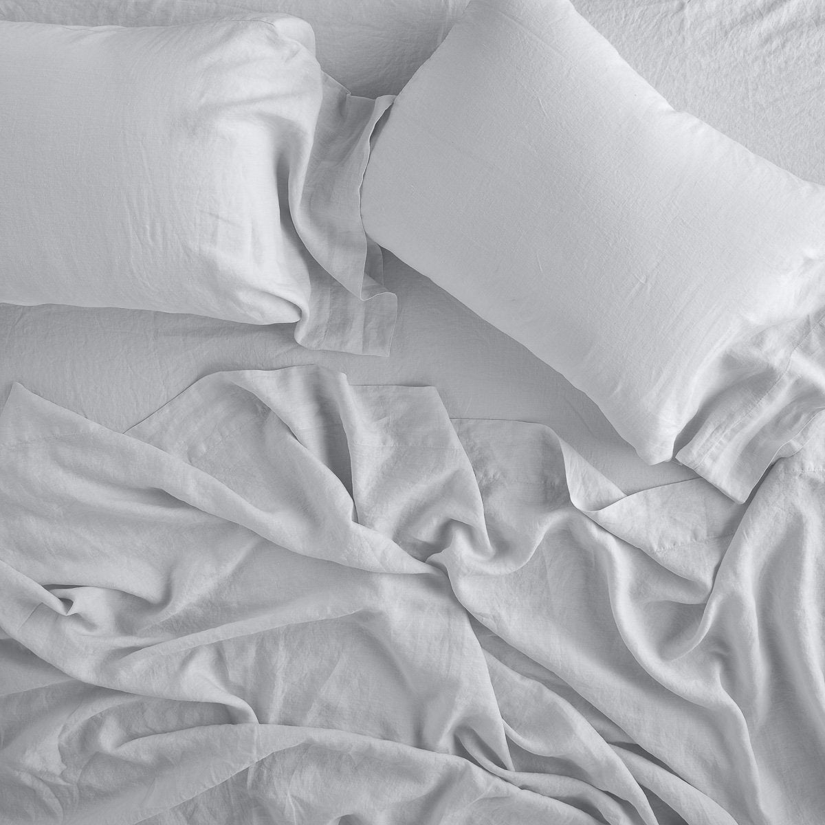 Sterling: sleeping pillows laid flat on rumpled matching sheeting - overhead view.