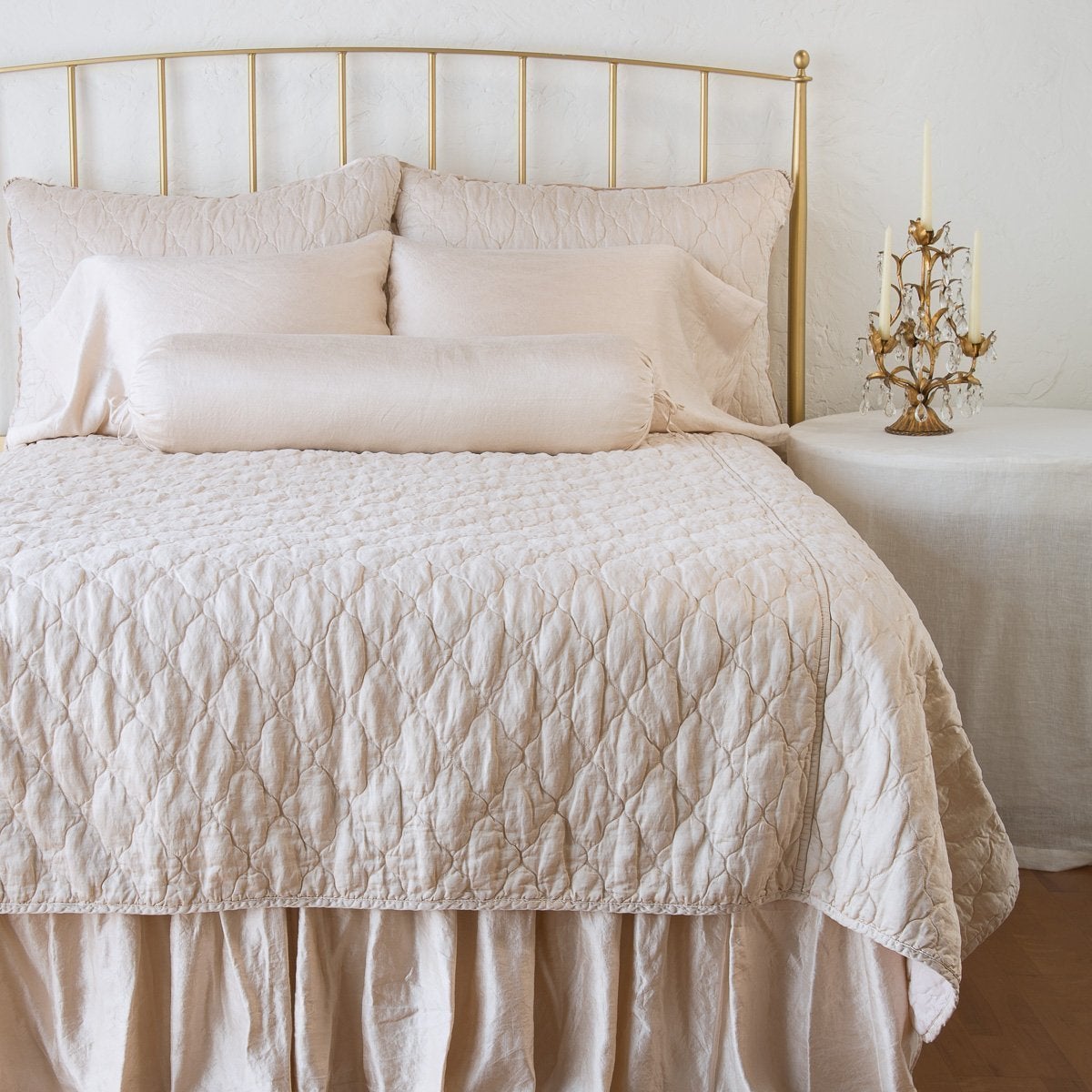 Pearl: coverlet on a shining, monochromatic bed with matching shams - end of bed view.