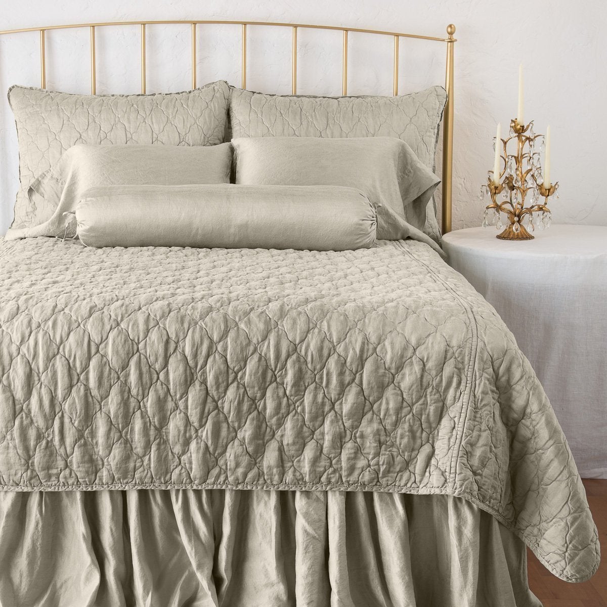 Fog: shams on a shining, monochromatic bed with matching coverlet - end of bed view.