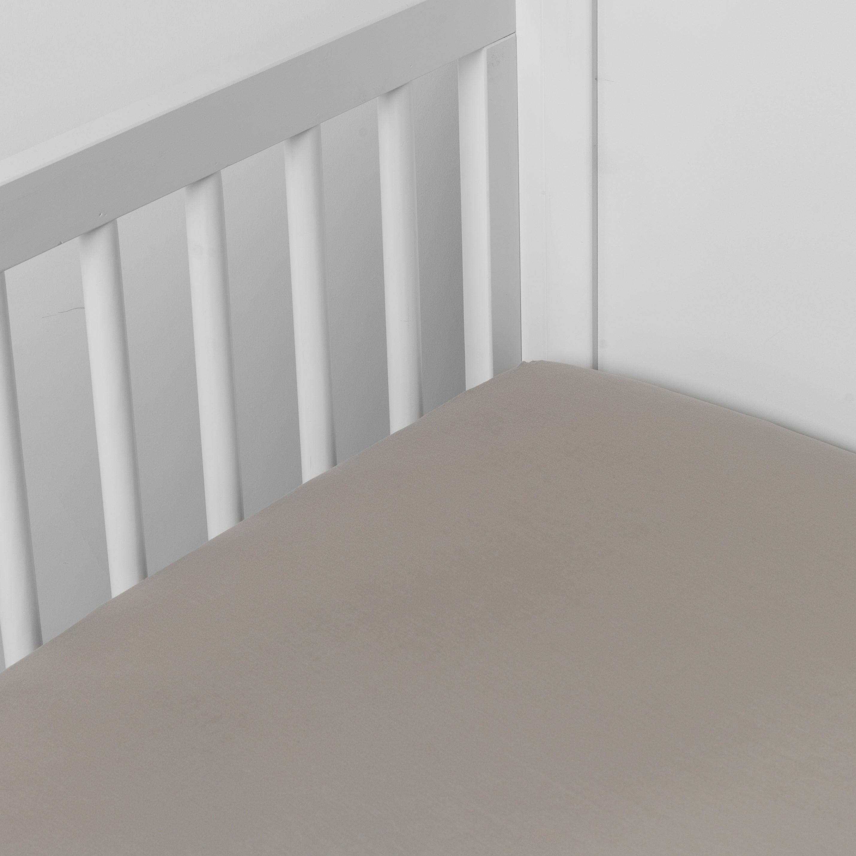 Fog:  crib sheet shown on a mattress shown from overhead into the corner of a crib. 