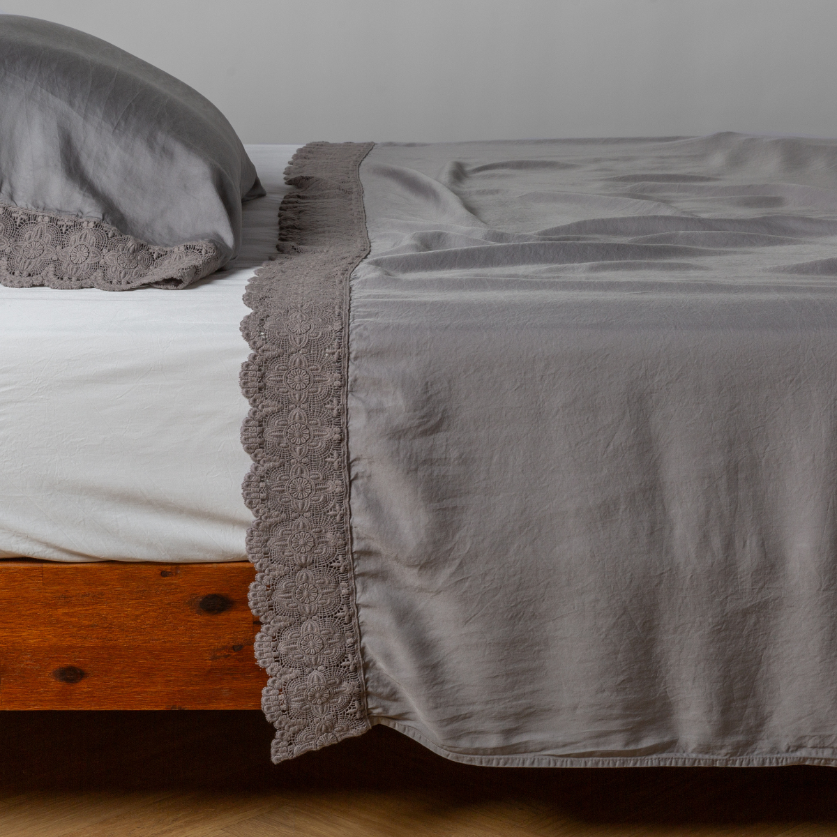 matching cotton lace trimmed flat sheet and pillowcase shown with simple white sheet - side view.